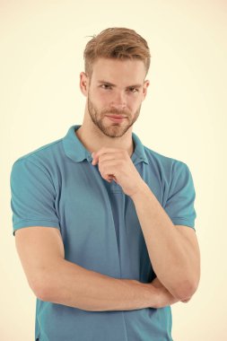 Tıraşsız yüzlü sakallı bir adam. Mavi tişörtlü sakallı adam. Beyaz arka planda izole edilmiş şık saçlı bir manken. Cilt bakımı ve berber salonu. Tarz eğilimi ve saç stili konsepti