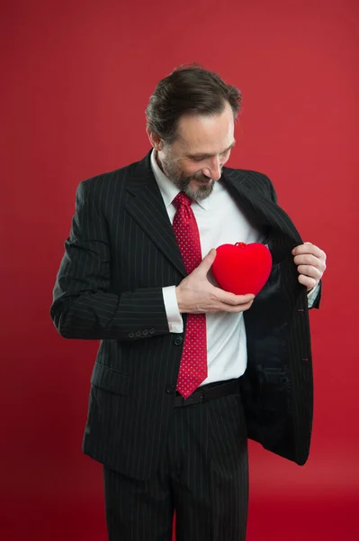 Sorpresa para ella. hombre de negocios con barba en traje. El hombre maduro sostiene el corazón de San Valentín. Amor y romance cuidado de la salud. Problemas de corazón. Un hombre feliz con un gran corazón rojo. Entrenador. trasplante de corazón — Foto de Stock