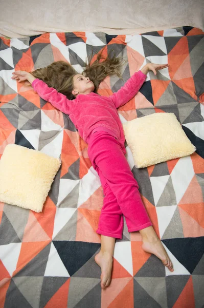 Bébé fatigué relaxant. Pyjama et vêtements pour la maison. Pyjama et textile de chambre. Les enfants aiment les loisirs. Pyjama confortable pour se détendre. Fille petit enfant porter un pyjama mignon doux tout en se relaxant sur le lit — Photo