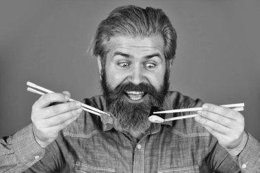 Japonya 'da geleneksel yiyecekler. Şef yemek servisi. Asya yemeği. Suşi siparişi. Sushi teslimatı. Mutlu adam suşi yer. Çubuklu suşi ve zencefil. Japon mutfağı.