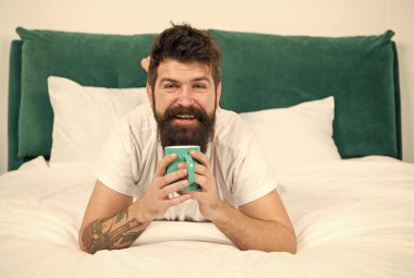 Acele etme, kahve iç. Mutlu hipster yatakta kahve içer. Sakallı adam sıcak içecekten hoşlanır. Kahvaltı içkisi. Güzel kahve. Günaydın.