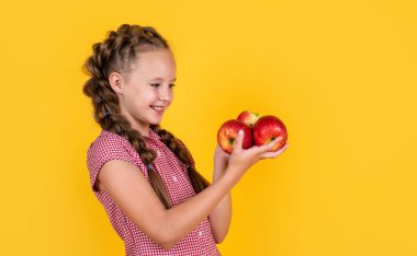 Şuna bir bak. Vitamin dolu. Gülümseyen çocuk kırmızı elmayı tutuyor. Vejetaryen diyeti. Sonbahar hasadı.