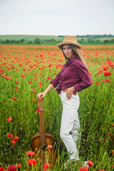 Campagne printanière. dame porter chemise à carreaux et chapeau dans le champ de fleurs. chanteur de country. — Photo