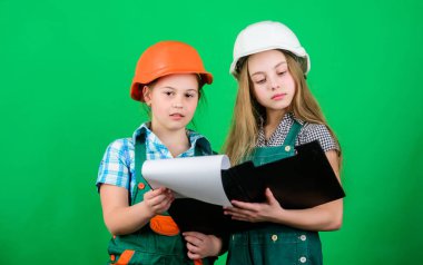 Kasklı ve tabletli küçük çocuklar. Okul projesi. Mutlu çocuklar. Foreman müfettişi. İşçi bayramı. Olabilir. Küçük kızlar atölyede birlikte tamirat yapıyorlar. Ustabaşı çocuklar. Kasklı ustabaşı. Foreman çocukları