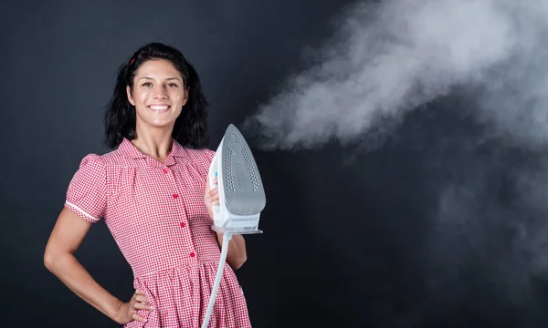 It is so hot. attractive beauty with brunette hair use home appliances. female householding. happy woman presenting steaming iron. girl in retro dress ironing. housewife has domestic duties — Stock Photo, Image