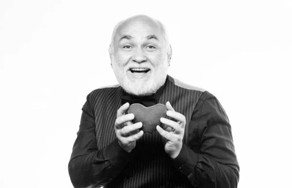 Kalp krizini önlüyor. Yaşlı kel sakallı adam elinde kırmızı oyuncak bir kalp tutuyor. Sevgililer günü kalbi olan olgun bir adam. Kalp sorunu ve sağlık sigortası. Kalp atışları ve tedavi. Sağlık hizmetleri — Stok fotoğraf