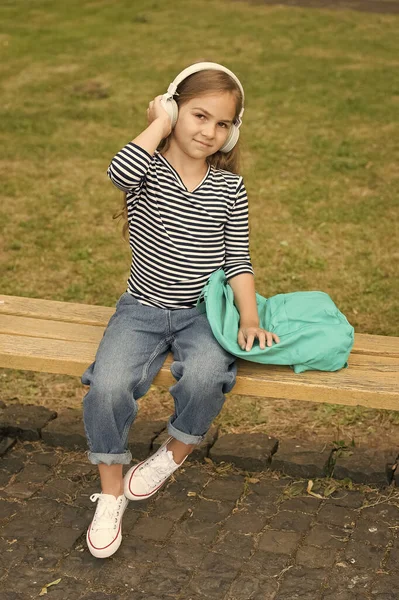 Koniec szkoły, koniec lata. Dzieciak słucha muzyki w słuchawkach na zewnątrz. Wakacje. Święta szkolne. Edukacja muzyczna. Zabawa i rozrywka — Zdjęcie stockowe