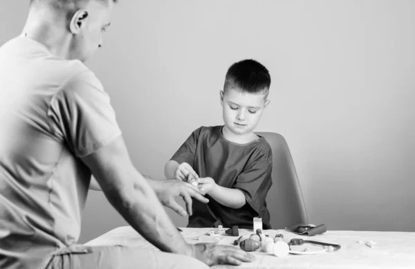 Il piccolo dottore si siede al tavolo degli attrezzi medici. Assistenza sanitaria. Concetto pediatrico. Visita medica. Ragazzo bambino carino e suo padre medico. Operaio ospedaliero. Servizio medico. Laboratorio di analisi — Foto Stock