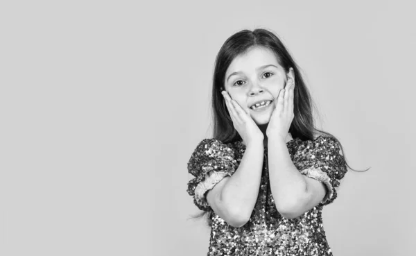 Un visage précieux. L'enfant lève ses joues avec affection. Fille sourire mignon sur fond jaune. Concept d'enfance et de bonheur. Enfant avec un espace de copie de visage joyeux. Joyeuse journée des enfants. Bonne enfance — Photo