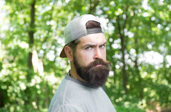 Hombre barbudo maduro con gorra. vacaciones de campamento de verano. hombre hipster senderismo. cuidado de la barba masculina. brutal hipster en el bosque. descubrir nuevos lugares. Hora del picnic. caucásico chico con bigote — Foto de Stock