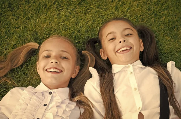 Gelukkige kindertijd. Gelukkige kinderen ontspannen op groen gras. Genieten van kinderjaren. Bescherming van de jeugd. Kinderopvang centrum. Jeugdgeluk. Internationale kinderdag — Stockfoto