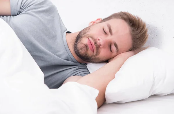 Perdido en un sueño profundo. Durmiendo hasta tarde disfrutando del sueño por la mañana. Un hombre guapo durmiendo en la cama. No lo despiertes por la mañana. Necesita dormir más. — Foto de Stock