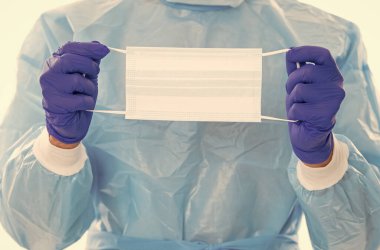 Cerrahi eldivenli ve koronavirüs salgınına karşı güvenlik kostümlü doktorların koruması için solunum maskesi, covid virüs..