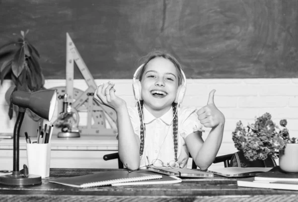 Σνακ ανάμεσα στα μαθήματα. Μαθήτρια κάθεται γραφείο chalkboard φόντο. Μαθητής στο σχολείο. Υγιεινός τρόπος ζωής Σχολική ζωή. Σύγχρονη παιδική ηλικία. Σχολικές διακοπές. Κορίτσι μικρό παιδί τρώει μηλόπιτα — Φωτογραφία Αρχείου