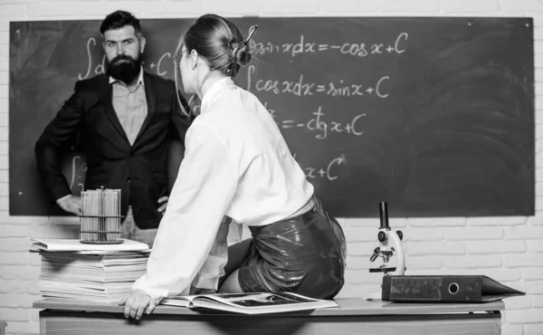 모두 가 그러 한 선생을 꿈꾸고 있다. 가죽 치마입은 매력적 인 선생님. 건방진 선생님. 열렬 한 학생이다. 남자가 칠판에 서 있는 동안 섹시 한 여자가 테이블에 앉아 있습니다. 동료들 과어울리는 거요. 과학은 섹시하다 — 스톡 사진