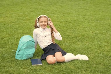 Küçük kız kitabı tutuyor. Çocuklar için edebiyat. Çocukluk gelişiyor. Defterle çalış. Okula dönüyorum. Çocuk parkta ders çalışıyor. Kitapla birlikte yeşil çimlerin üzerinde rahatla. çevrimiçi müzik dinlemek. Boşluğu kopyala