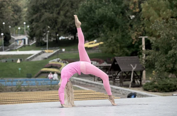 Hezká mladá žena dělá jógu asanas v parku — Stock fotografie
