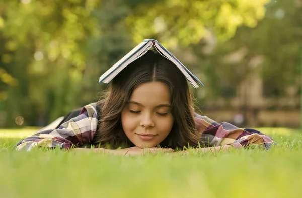 Beruhigendes Buch. Kleine Kinder schlafen auf grünem Gras. Bibliotherapie. Achtsamkeit und Entspannung. Mittagsschlaf. Zurück zur Schule. Nicht formale Bildung und Lernen. Entspannendes Buch für besseren Schlaf — Stockfoto