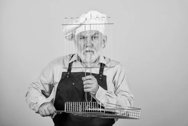 Koken met passie. kookgerei voor de barbecue. Hij geeft de voorkeur aan grillvoedsel. Picknick en barbecue. Keukenregels. Maak het eten klaar voor familie. Familieweekend. Oudere man met koksmutsen. koken mannen met baard — Stockfoto