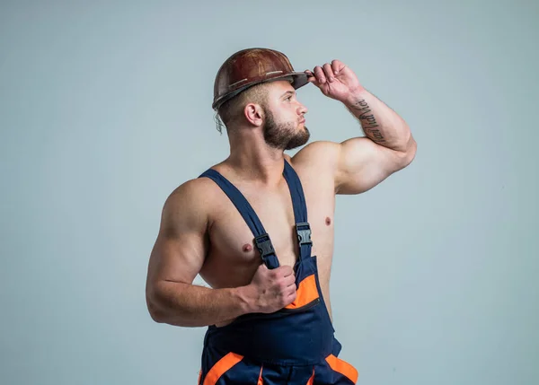 Mayolu seksi bir müteahhit. İnşaat alanındaki kaslı adam. Sert şapkalı yakışıklı bir inşaat işçisi. İşçi bayramı. Atletik adam güvenlik kaskı takıyor. Mühendis çalışıyor. erkek yaşam tarzı — Stok fotoğraf