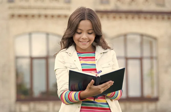 Escribir un diario. El alumno de la escuela hace tareas de escritura al aire libre. Niño feliz escribe en copybook. Tomando notas. Lección de escritura. Aprender lengua extranjera. Gramática inglesa. Mejorar la escritura manual — Foto de Stock