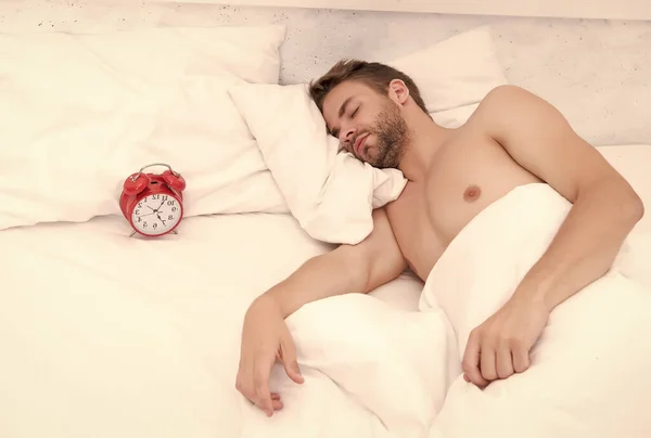 Man sover säng vita sängkläder och röd väckarklocka, djup sömn koncept — Stockfoto