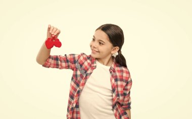 Bir kişi, binlerce duygu. Küçük kız kalp oyuncakları tutuyor. Kırmızı kalpli tatlı bir kız. Çocuk sevgi sembolü taşıyor. Sevgililer günün kutlu olsun. Aile sevgisi kavramı. Sıcak ve hoş anılar.