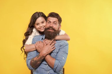 Aşk ana bileşendir. Mutlu kız babaya sevgiyle sarılıyor. Sakallı adam ve küçük çocuk. Mutlu aile sarı arka planı. İlişki ve ilişkiler. Köklü ve köklü bir aşk. Güven ve özen