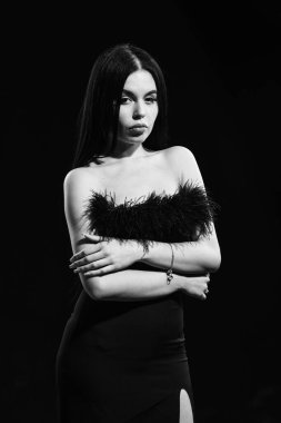 Moda konsepti. Sadelikte zarafet. Siyah mükemmel. Göz kamaştırıcı bir tarz. Süslü kıyafetler. Moda dükkanı. Tüy süslemeleri. Zarif kadın model. Tüylü elbise giyen şık bir kız.