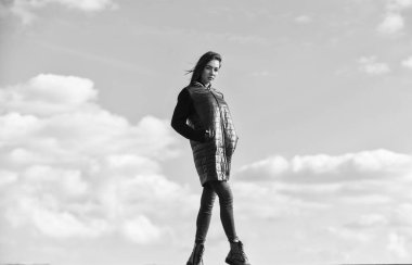 Yalnız yürüyorum. Hayalperest kız. Genç ve özgür bir kavram. Kıyafetlerinden daha fazlasını bekle. Kadınlar açık havada havadan hoşlanır. Güzellik ve moda. Mavi gökyüzü arka planında bir kadın. Kış tatili Uzun ceket.