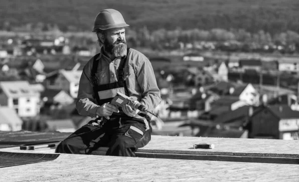 Roofer construyendo techo. Superficie del techo del hombre. Requisitos de materiales. Instale capas parcialmente superpuestas de material sobre las superficies de aislamiento del techo. Techo de reparación maestro. Instalación de techo plano —  Fotos de Stock