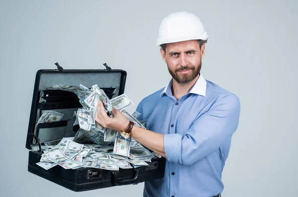Knappe lachende bebaarde zakenman in helm houden geld geval, financieel — Stockfoto