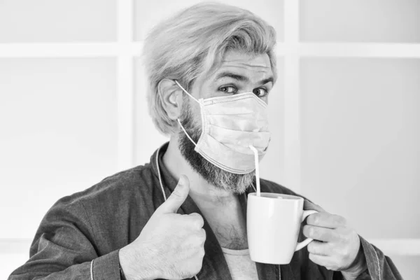 Beste ademhalingsmasker. Ziekenhuis of vervuiling te beschermen gezicht maskeren. medisch masker als corona bescherming. Een man drinkt koffie in een masker. uitbraak van een coronavirus-pandemie — Stockfoto