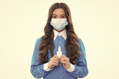 Burun akıntısı koronavirüs semptomu. Grip salgını terapisi. Semptomatik tedavi. Virüs salgını riski var. Çocuk etkili ilaçlar kullanıyor. Maskeli kız burun damlası tutuyor. Burun spreyi salgılayan çocuk