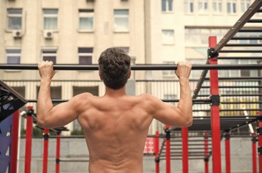 Adam kaslı sırt sporcusu düzgün formda barfiks çekiyor, spor konsepti.