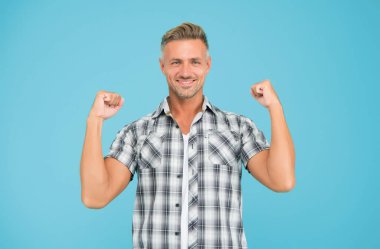Sıradan ve güçlü. Güçlü adam kollarını mavi arka planda açar. Sıradan tarzda yakışıklı bir adam. Sıradan moda trendleri. Moda ve tarz. Rahat hissediyorum. Sıradan görünüş
