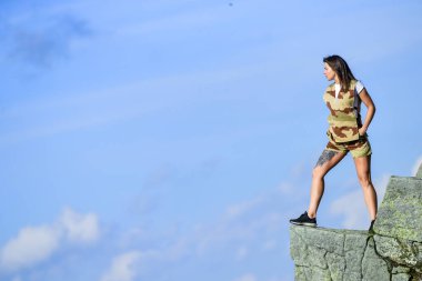 Cesur kadın yüksek dağlarda tek başına mavi gökyüzü arka planında duruyor. Depresyon kavramı. Asker kız. Askeri kadın. Gözlem noktası. Cesur kız tehlikeli uçurum. İntihara meyilli. Cesur ve korkusuz.