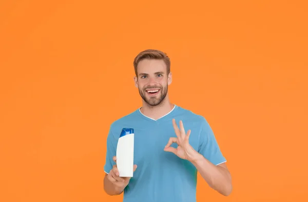 Cuidado personal. terapia de baño perfecta. asistente de tienda amigable. hombre feliz celebrar botella de champú. tipo lavando el cabello con mousse. peluquería y peluquería. publicidad de gel hidratante médico — Foto de Stock