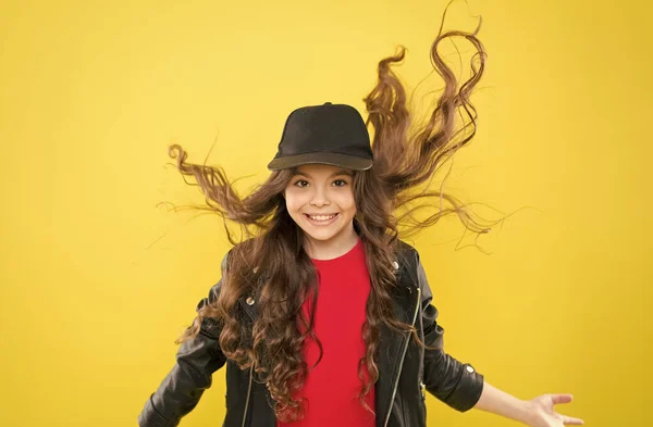 Feeling good fabulous hair. Happy child with long wavy flowing hair. Beauty salon. Haircare cosmetics. Hairdressing and beauty therapy. Shampooing and conditioning. Styling and twisting