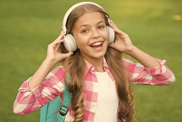 Auriculares diseñados para ayudarle a relajarse. Feliz bebé usar auriculares al aire libre. Los niños pequeños escuchan música con auriculares. Auriculares de diseño moderno. Nueva tecnología. Gadget fresco — Foto de Stock