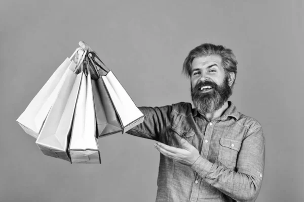 Home shopping. Extremely happy hipster making purchases at electronics store. Positive man enjoying shopping. Own business. bearded man hold paper bag. presents. Delighted man shopping online