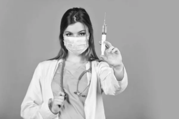 Επιδημία του κορωνοϊού από την Κίνα. επιλεκτική εστίαση. η γυναίκα γιατρός χρησιμοποιεί σύριγγα. η νοσοκόμα κάνει την ένεση με μάσκα αναπνοής. ο υπεύθυνος υγείας καλεί το εμβόλιο σε σύριγγα. Γιατρός ή δότης εμβολίου κατά του ιού — Φωτογραφία Αρχείου