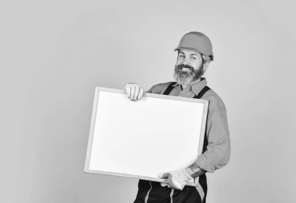 Problemen oplossen concept. Reparateur houdt whiteboard kopieerruimte. Knappe reparateur. Baard man reparateur bouwer. Reparatie van plannen. Visuele omtrek. Architect toont project. Professionele reparateur — Stockfoto