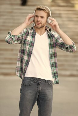 Bizi izlemeye devam edin. Yakışıklı adam dışarıda kulaklık takıyor. Modern müzik. Modern zaman cihazı. Hi-Fi ses sistemi. Yeni teknoloji. Modern yaşam tarzı. Modern hayat. Keyfine bak.