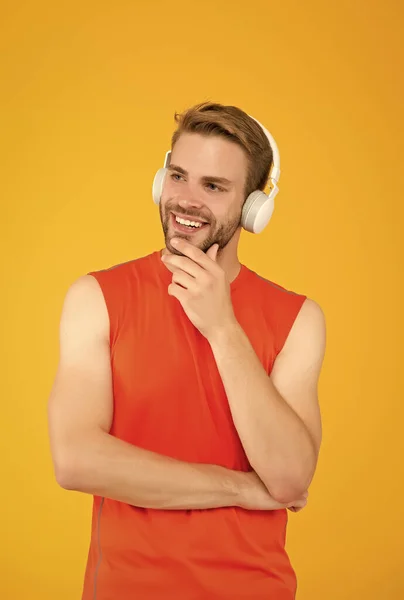 Felice uomo barbuto ascoltare musica in auricolari digitali indossando vestiti sportivi per l'allenamento, divertimento — Foto Stock