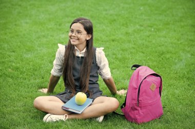 Beyninin sağlığını koruyorum. Mutlu çocuk yeşil çimlerde rahatla. Okul tatili. Beslenme eğitimi. Okul yemeği. Sağlıklı beslenme alışkanlıkları. Öğrenmek için yemek