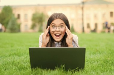 Mükemmel bir gün. Çalıştır. Çocuk bilgisayar oyunu oynuyor. Okula dönüyorum. İnternet eğitimi. Bilgi günü. Çocuk özel ders öğreniyor. Blog yazıyorum. Yeşil çimlerde dizüstü bilgisayarla oturan mutlu kız.