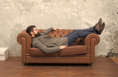 Lüks deri koltukta rahatlayan adam, mobilya mağazası konsepti.