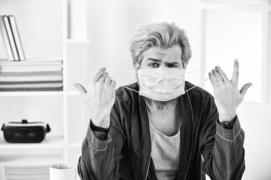 Adam yüz maskesi tutuyor. Virüs damlacıklarla ve yakın temasla bulaşır. Maske takıyor Virüslerden koruyor. Eğer maske takıyorsan, nasıl kullanılacağını ve nasıl kullanılacağını bilmelisin. Koronavirüsten koru.