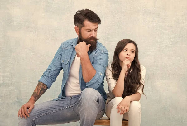 Be what you want to be and wear what you like. Bearded man look at small child. Father and daughter sit on stool. Fashion wear. Casual style. Fashion trends. Trendy style. Hair salon. Barbershop